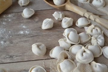 Fototapeta na wymiar Frozen raw dumplings close up on shabby wooden background