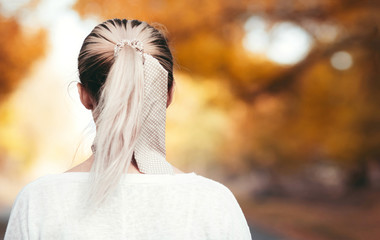 back of female head on the background of the jogging track on asphalt road, girl with ponytail for...