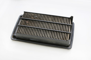 Dirty used car air conditioner filter on white background.