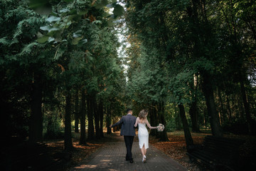 Fototapeta premium Wedding couple walks along a dark forest path