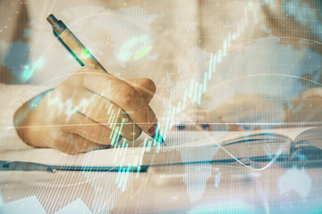 Multi exposure of woman's hands making notes with forex graph hologram. Concept stock market...