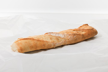 fresh baguette on textured white background
