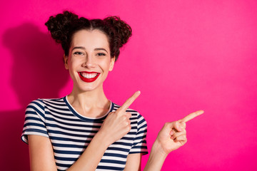 Photo of cheerful cute nice curly wavy youngster pointing at empty space smiling toothily isolated...