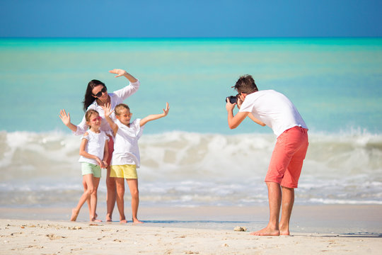 Family of four taking a selfie photo on their beach holidays. Family beach vacation