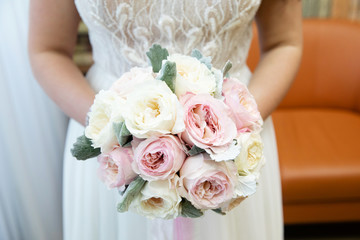 Beautiful wedding bouquet of flowers in the hands of the bride