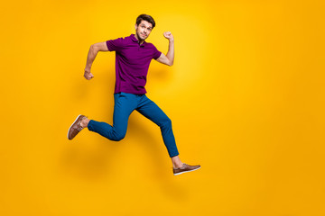 Fototapeta na wymiar Full length body size turned photo of surprised man running as fast as he can towards shopping mall to come for sales on time wearing blue pants trousers shoes isolated vivid color background
