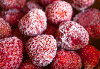 Frozen strawberries in a bowl with hoarfrost.