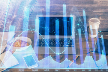 Double exposure of graph and financial info and work space with computer background. Concept of international online trading.