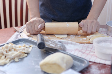 Cropped view woman roll the dough on wooden board
