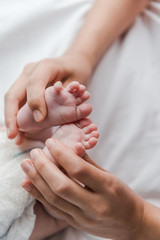 selective focus of mother doing massage while touching legs of infant baby
