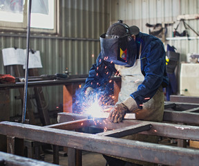 Worker welds steel construction