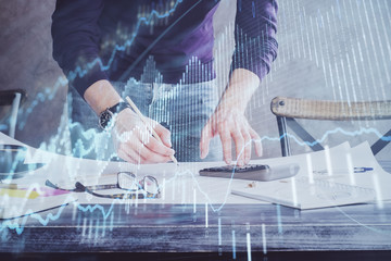 Multi exposure of man standing and planing investment with stock market forex chart.