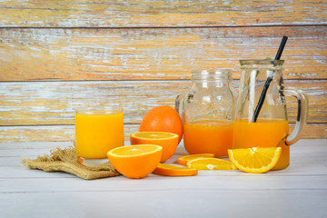 Orange juice in the glass jar and fresh orange fruit slice on wooden table - Still life glass juice on wood background