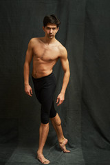 Obraz premium Male ballet dancer posing in studio on a black background