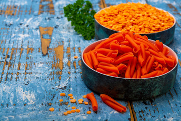 Orange gluten free diet pasta made from lentils  legumes on blue wooden table