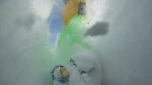 the professional snowboarder blasts the plumper and raises big waves and swirls of snow around him. the camera is mounted on the toe of the snowboard and is aimed at the Freerider. riding fresh powder