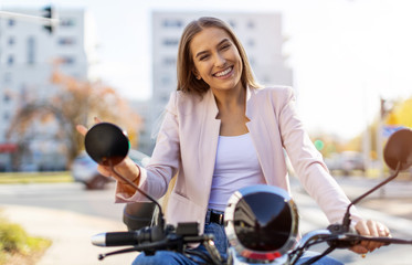 Happy young woman out for a scooter ride