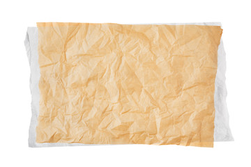 Crumpled piece of brown baking paper over white paper or parchment isolated on white background. Top view. Copy space for text. Design element.