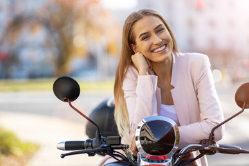 Happy young woman out for a scooter ride