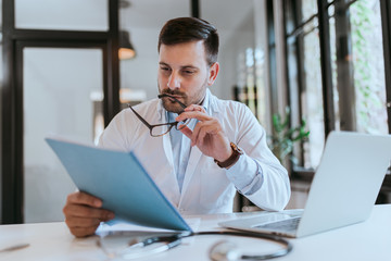 Portrait of a doctor reading a file.