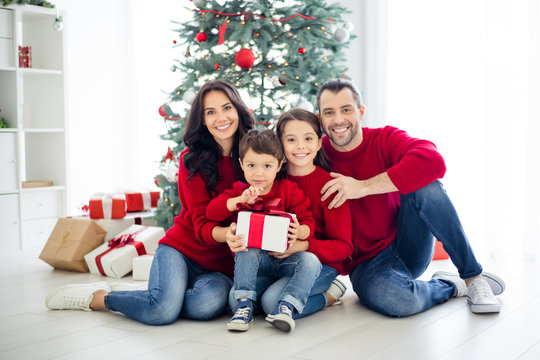 Full body photo of big full charming dad mom schoolgirl small boy holding package for christmas night enjoy x-mas having brunet hair wearing red pullover denim jeans in house indoors