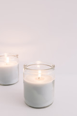 Two burning candles in glass candlesticks