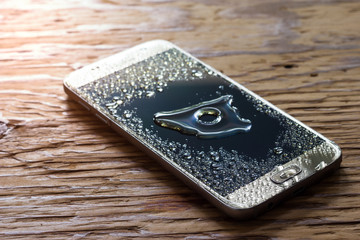 Closeup wet smartphone drops on wooden floor