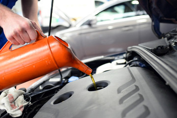 Motorölwechsel in der Autowerkstatt beim PKW // Engine oil change in the car repair shop at the...