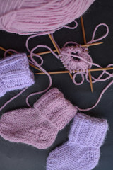 Fototapeta na wymiar Pink and purple baby socks, made of warm and soft woolen yarn