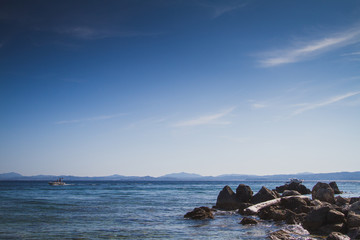 sea, tree on rocks and blue sky