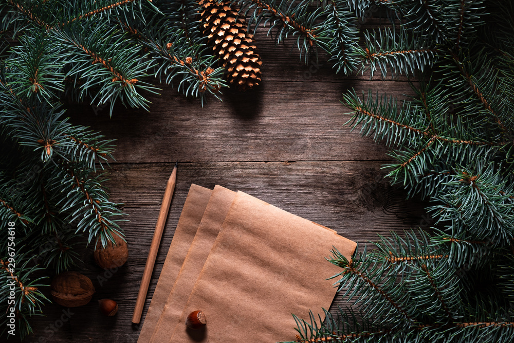 Wall mural christmas frame from fir branches on a background of an old gray board around an open notebook with 