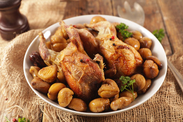 baked quail with chestnut- autumn dish on wood background