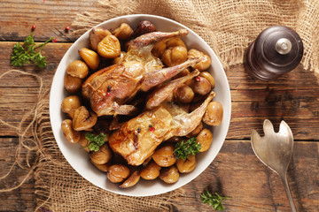 baked quail with chestnut- autumn dish on wood background