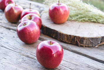 Ripe juicy red apples lie on a wooden table. Vitamins and a healthy diet. Vegetarian concept.