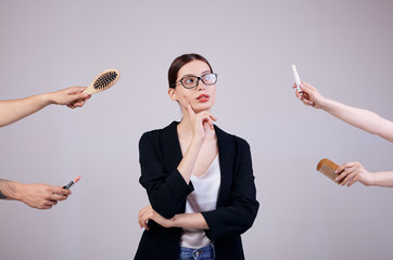 Serious business woman is standing on a gray background in a jacket, white T-shirt and computer...
