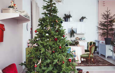 the classic interior of the living room is decorated with a chic Christmas tree, gifts