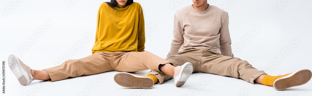 Wall mural panoramic shot of man and woman sitting on white