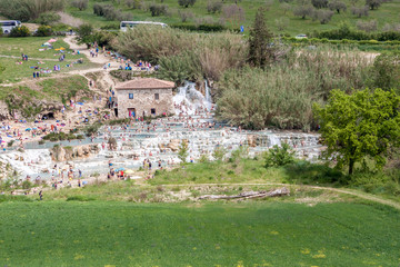 Obraz premium Tourists swimming and relaxing in hot springs - Saturnia, Tuscany - Italy.