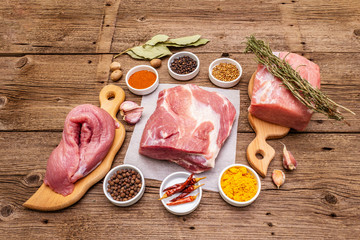 Assorted various fresh pork cuts. Raw meat with spices. Tenderloin, shoulder blade, neck
