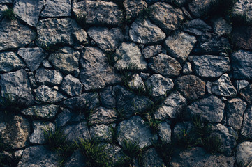 Natural granite stone wall wide texture, gloomy gothic background.
