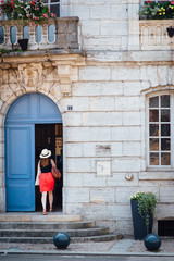une femme &eacute;l&eacute;gante entre par une vieille porte coch&egrave;re