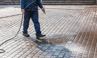 Worker cleaning the street sidewalk