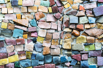 Colorful ceramic mosaic, decorative art fragment of a wall decorated with construction mosaic. Multi-colored ceramic stones.  Abstract texture and background for design,selective focus