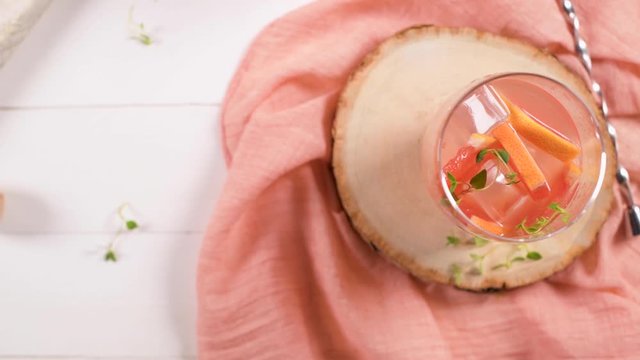 Healthy summer drink grapefruit lemonade with thyme in glasses with ice on a wooden surface.