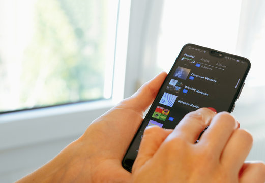 Spotify music app hand smartphone playlist scrolling
