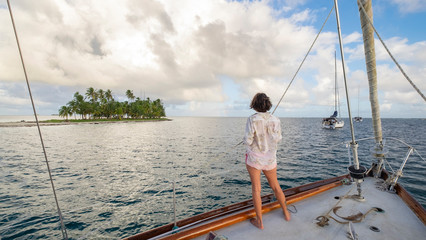Sailing boat with woman looking at San Blas island, Panama
