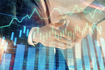 Double exposure of financial graph on cityscape background with two businessman handshake. Concept of stock market deal