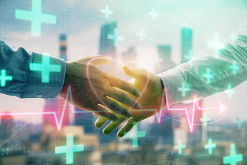 Double exposure of heart drawing on city view background with handshake. Concept of medical education