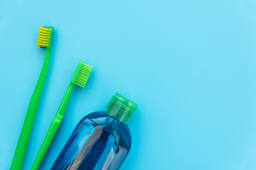 Mouthrinse, original and orthodontic toothbrushes on blue background. Healthy lifestyle. Flat lay. Top view