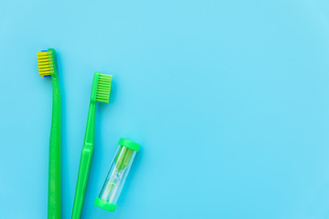 Timer, original and orthodontic toothbrushes on blue background. Healthy lifestyle. Flat lay. Top view